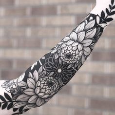 a woman's arm with black and white flowers on it