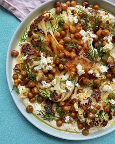 a white plate topped with cauliflower and chickpeas