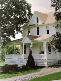 a large white house sitting on top of a lush green field