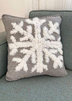 a gray and white pillow sitting on top of a couch