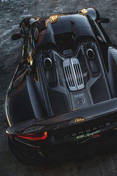 an overhead view of a black sports car with its hood down and the engine visible