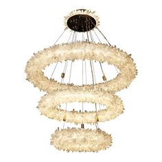 a chandelier with white feathers hanging from it's center and two circular lights