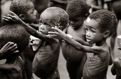 several young children are playing with mud on their faces and hands in black and white