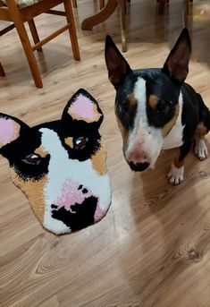 a dog standing next to a fake head on the floor