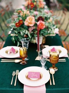 the table is set with pink and green place settings