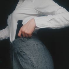 a man in a white shirt is holding his pants