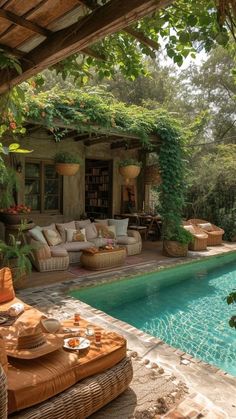 an outdoor living area next to a swimming pool with wicker furniture on the patio