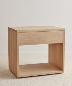 a small wooden table sitting on top of a white carpet