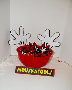 a bowl filled with lots of candy sitting on top of a white table next to a sign that says moutakatools