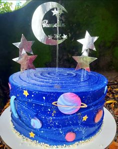 there is a blue cake with stars and planets on it