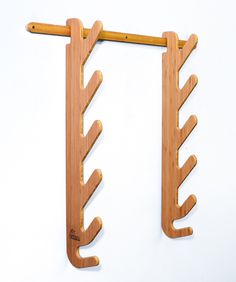 a pair of wooden hooks hanging from the side of a wall