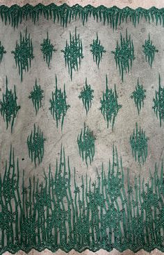 an old cloth with green thread work on it