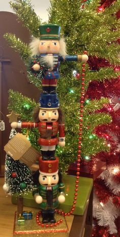 nutcrackers are stacked on top of each other in front of a christmas tree