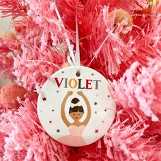 a christmas ornament hanging from the side of a pink tree