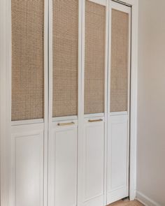 an empty room with white doors and wicker screens on the walls, along with wood flooring