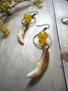 "Genuine Coyote teeth , cleaned then stained to look antique are wired wrapped and dangle from antiqued brass hoops The ring also acts as a halo for faceted golden Citrine rondelles. French hooks finish these babies off to 2 3/4\" I hope you enjoy my handmade creations, or that special vintage notion you found in my shop! x and o , Chymiera" Handmade Rustic Brass Jewelry, Full Wolf Moon, Rustic Earrings, Scented Sachets, Animal Bones, Wolf Moon, Brass Hoops, Moon Earrings, Citrine