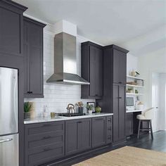 a kitchen with gray cabinets and stainless steel appliances