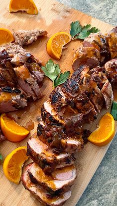 sliced meat and oranges on a cutting board