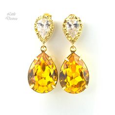 "These timeless Swarovski Yellow Earrings have a Victorian touch of elegance and romance! A bright, happy and super sparkly jewelry that will light up your day!  I made the gorgeous Earrings with: - the Genuine and unique 18x13mm Swarovski Sunflower Yellow teardrop pear shaped fancy stones, set in gold plated settings - Hypoallergenic and tarnish resistant, 16k gold plated pear shaped ear posts with AAA cubic zirconia stones - these are approx 1 1/4\" from top of the ear posts to bottom of the s Elegant Hypoallergenic Yellow Earrings, Elegant Yellow Dangle Clip-on Earrings, Elegant Yellow Clip-on Jewelry, Yellow Teardrop Earrings For Wedding, Yellow Dangle Earrings For Wedding, Elegant Yellow Clip-on Earrings, Yellow Clip-on Earrings For Anniversary, Elegant Yellow Bridal Earrings For Wedding, Elegant Yellow Crystal Dangle Earrings