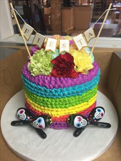 a multi colored cake decorated with flowers and flags