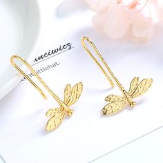 The 14K Gold Dangle Dragonfly Earrings are a stunning and unique piece of jewelry. Each earring features a delicate dragonfly charm that dangles gracefully from a 14K gold ear wire. The dragonfly charm is intricately designed with detailed wings and a long slender body. The charm is made of 14K gold, which gives it a warm, rich glow and durability. The dragonfly dangles from the ear wire, creating a subtle movement that catches the light and adds a playful touch to the earrings. These earrings a Gold Galaxy, Dragonfly Charm, Citrine Earrings, Dragonfly Earrings, Diamonds And Pearls, Gold Dangle Earrings, Black Diamonds, Threader Earrings, Ear Rings