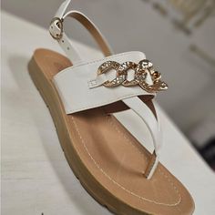 White Thong Sandal With Gold Chain Detail On Top Band. Tts Avril Soda Brand Trendy Beach Sandals With Chain Strap, Chic Beach Sandals With Chain Strap, Chic Sandals With Chain Strap For Vacation, Chic Vacation Sandals With Chain Strap, Flat Sandals With Chain Strap For Beach, Chain Strap Sandals For Vacation, Beach Sandals With Chain Strap For Summer, Summer Vacation Sandals With Chain Strap, Casual Sandals With Chain Strap For Vacation