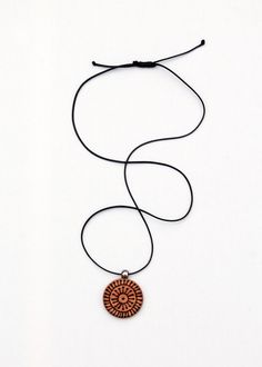 This is a wooden necklace inspired by traditional Croatian tattoos.  In the 19th century, Croatian women in Bosnia and Herzegovina had been tattooed at an early age as a form of protection and to show they were Christians. They tattooed their arms and chest, but some even tattooed their faces.  There were many beautiful motifs.  This motif, in particular, was found in 1894 by archeologist Ciro Truhelka. The necklace is made of wood and it is coated with linseed only.  The cord is waxed polyester Brown Medallion Amulet Necklace, Bohemian Brown Hand Painted Necklaces, Bohemian Hand Painted Brown Necklace, Bohemian Brown Hand Painted Necklace, Brown Carved Round Pendant Necklace, Symbolic Brown Pendant Necklace, Brown Engraved Jewelry For Festivals, Brown Engraved Jewelry For Festival, Engraved Brown Jewelry For Festival