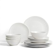 white dishes are stacked on top of each other in front of a white background,