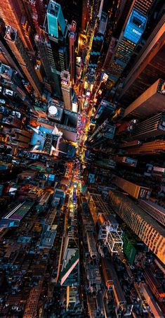 an aerial view of a city at night time with lots of tall buildings and lights