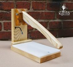 a small wooden device with a handle attached to it's side and the cover is made out of wood