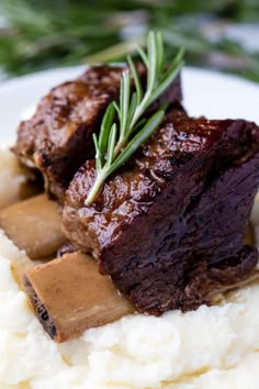 a white plate topped with mashed potatoes covered in gravy and meatloaf