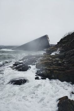 waves crashing on the rocky shore with an umbrella