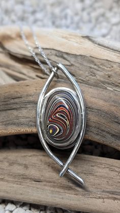 This  Corvette fordite, pre 2010, pendant necklace is handcrafted and set in sterling silver. It also comes with a 20 inch stainless steel chain.   I spend hours designing and handcrafting every pendant. It's very rewarding for me when I start with just sterling silver sheet and wire, and make it into a unique and one of a kind piece of jewelry.  If you would like additional pictures, please let me know and I will take some more. What is Fordite? Here's the story behind it. Years ago at a Ford plant, as the cars were painted, the overspray would build up on the racks and shelves in the paint booth. Eventually it was removed and a some employees brought some of that home and polished it up in much smaller pieces. Then others discovered it and started started creating things with it. That's Hebrew Jewelry, Fordite Jewelry, Leland Blue Stone, Blue Stone Pendant, Pendant Ideas, Paint Booth, Metalwork Jewelry, Fused Glass Jewelry, Motor City