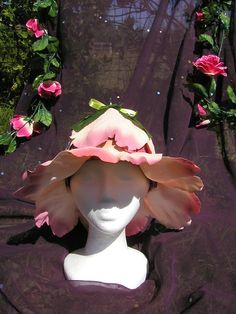 a mannequin's head wearing a pink hat with flowers on the top