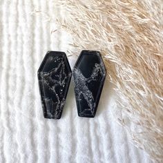 two pieces of black marble sitting on top of a white blanket next to each other