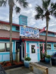 the outside of a blue building with palm trees in front and a sign that says harbus on it