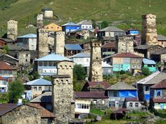 an aerial view of some very old buildings in the mountainside area with green grass and hills behind them