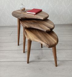 two wooden stools stacked on top of each other with a red book sitting on one end