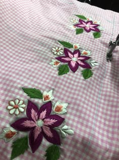 a pink and white checkered bedspread with flowers on it