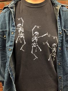 Skeleton Dancing Halloween Tee Shirt Perfect for the Halloween/Fall season! *TEE SHIRT INFORMATION* -Sizes are unisex. -If you prefer a larger fix, I recommend sizing up 1 size. -We offer sizes S-3XL. If you need a larger size, please message us and we may be able to special order. -100% Cotton, Comfort Colors brand. *CARE INFORMATION* -Please wash inside out on gentle settings and air dry for long lasting wear. -Do not dry clean. -Do not iron directly on graphic. *PROCESSING & SHIPPING* -Du Halloween Punk Shirt With Skull Print, Halloween Band Merch Shirt With Skull Print, Halloween Skull Print Band Merch Shirt, Halloween Punk Skull Print Shirt, Punk Skull Print Shirt For Halloween, Halloween Skull Print Shirt, Halloween Distressed Graphic Tee, Halloween Skull Print Crew Neck Shirt, Halloween Distressed Crew Neck T-shirt