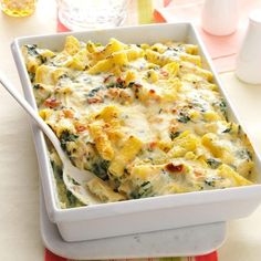 a casserole dish with cheese and spinach in it on a place mat