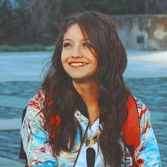 a woman with long brown hair smiling at the camera