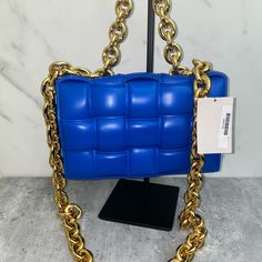 Padded Intrecciato Leather Crossbody Bag One Interior Zipped Pocket Metal Closure Material: 100% Lambskin Lining: Bonded Lambskin Color: Cobalt (Blue) Hardware: Gold Finish Height: 18 Cm | 7.1" Width: 26 Cm | 10.2" Depth: 8 Cm | 3.1" Handle Drop: 13 Cm | 5.1" Strap Drop: 50 Cm | 19.7" Made In: Italy Product Code: 631421vbwz08425 Comes With Dust Bag No Box Never Carried Never Used! Comes From A Smoke Free Pet Free Environment Luxury Blue Square Shoulder Bag, Designer Rectangular Shoulder Bag With Chain Strap, Luxury Blue Bag With Chain Detail, Luxury Rectangular Bag With Gold Chain, Luxury Blue Bags With Chain Detail, Blue Evening Bag With Chain Detail, Luxury Rectangular Bags With Gold Chain, Luxury Blue Bags With Chain, Luxury Blue Chain Bags