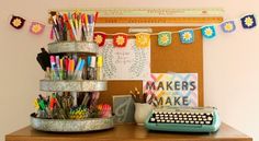 there is a desk with a typewriter, pens and markers on the top shelf