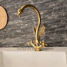 a gold dragon sculpture sitting on top of a white shelf next to a stone wall