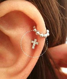 a close up of a person's ear with a cross on it