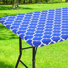 a blue and white table sitting in the grass