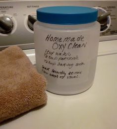 a jar of laundry deterant sitting on top of a dryer next to a towel