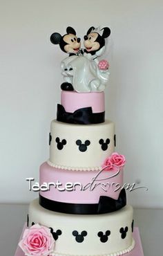 a three tiered cake decorated with mickey and minnie mouse figurines