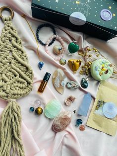 the contents of a purse laid out on a pink cloth with gold stars and beads